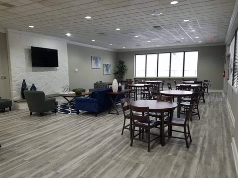 a large room with tables and chairs and a tv