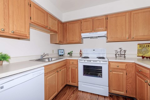a kitchen with white appliances and wooden cabinets
