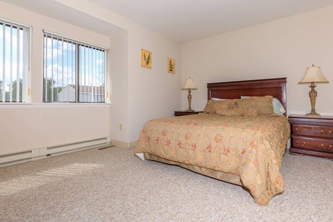 a bedroom with a bed and two windows
