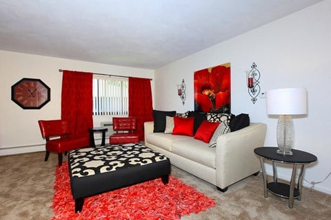 a living room with red chairs and a couch