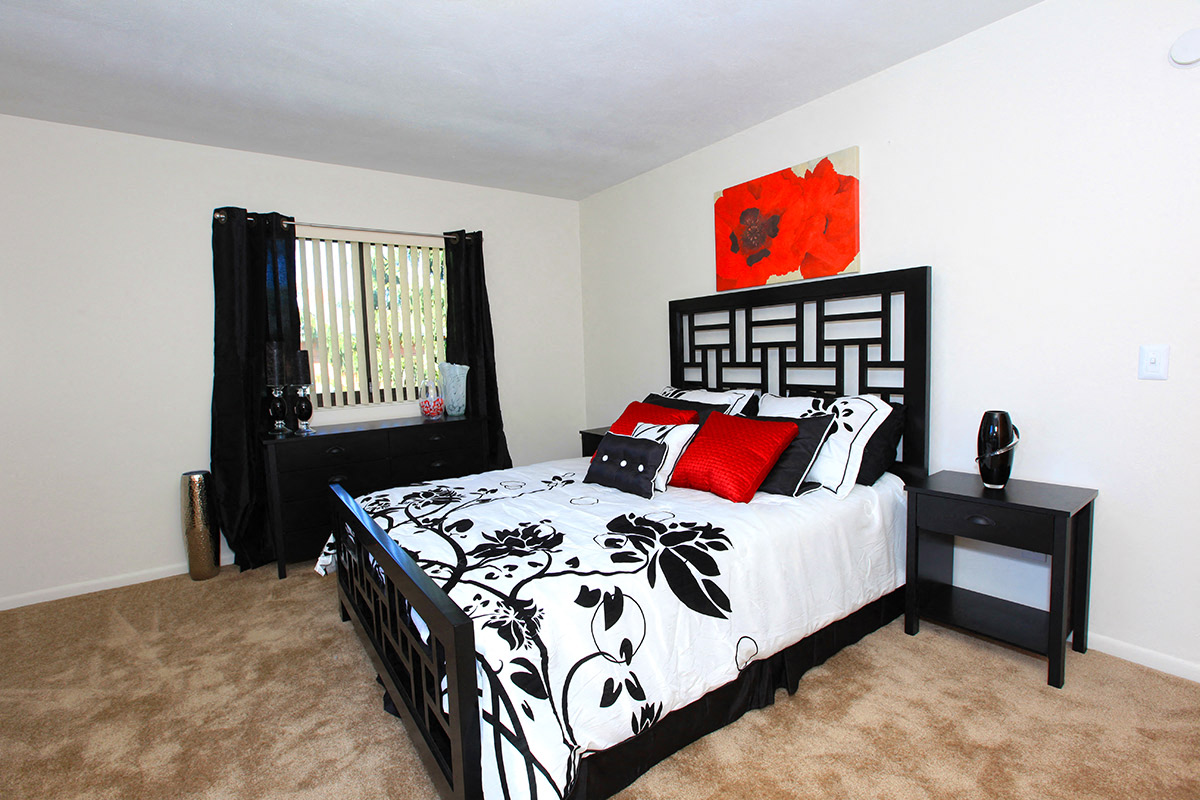 a black and white bedroom with a bed and a window