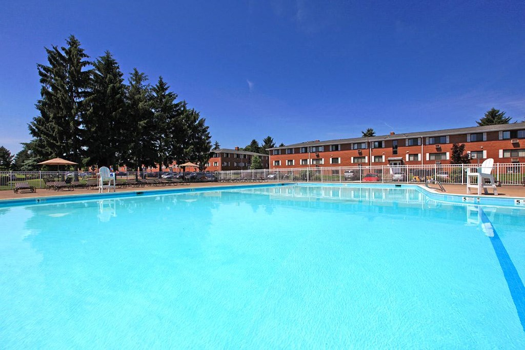 a large swimming pool with a hotel in the background