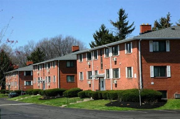 a red brick apartment building on the side of a street