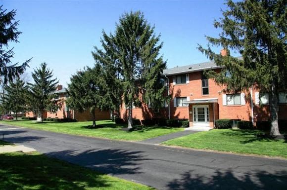 a row of brick apartment buildings on the side of a street