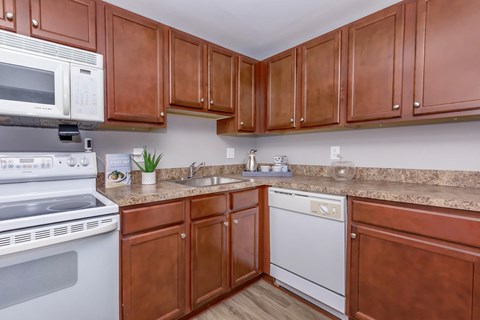 a kitchen with white appliances and wooden cabinets