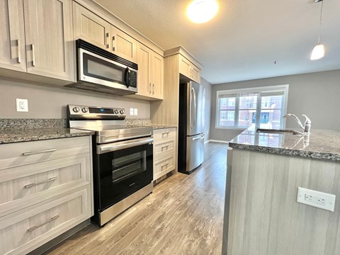 a kitchen with wooden cabinets and stainless steel appliances