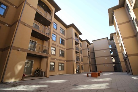 a courtyard in front of a row of apartments