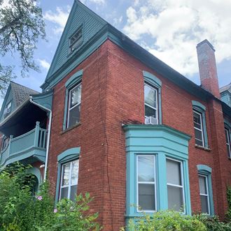 a brick house with blue trim and a blue roof
