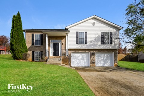 a white and brown house with black shutters and a driveway
