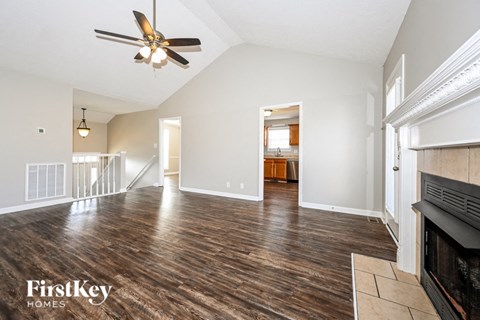 a living room with a fireplace and a ceiling fan