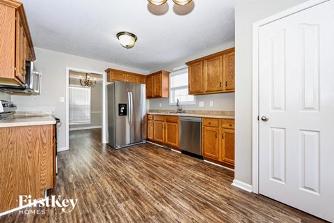 a kitchen with wooden cabinets and a stainless steel refrigerator