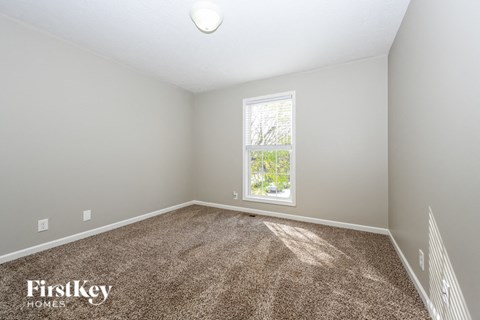 a bedroom with a carpeted floor and a window