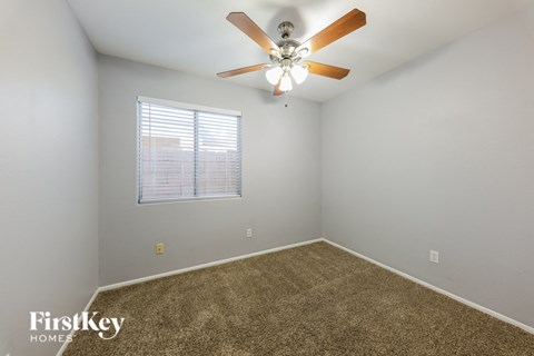 a bedroom with a ceiling fan and a window