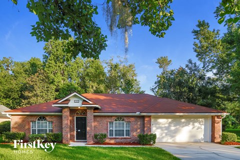 a brick house with a red roof and a garage