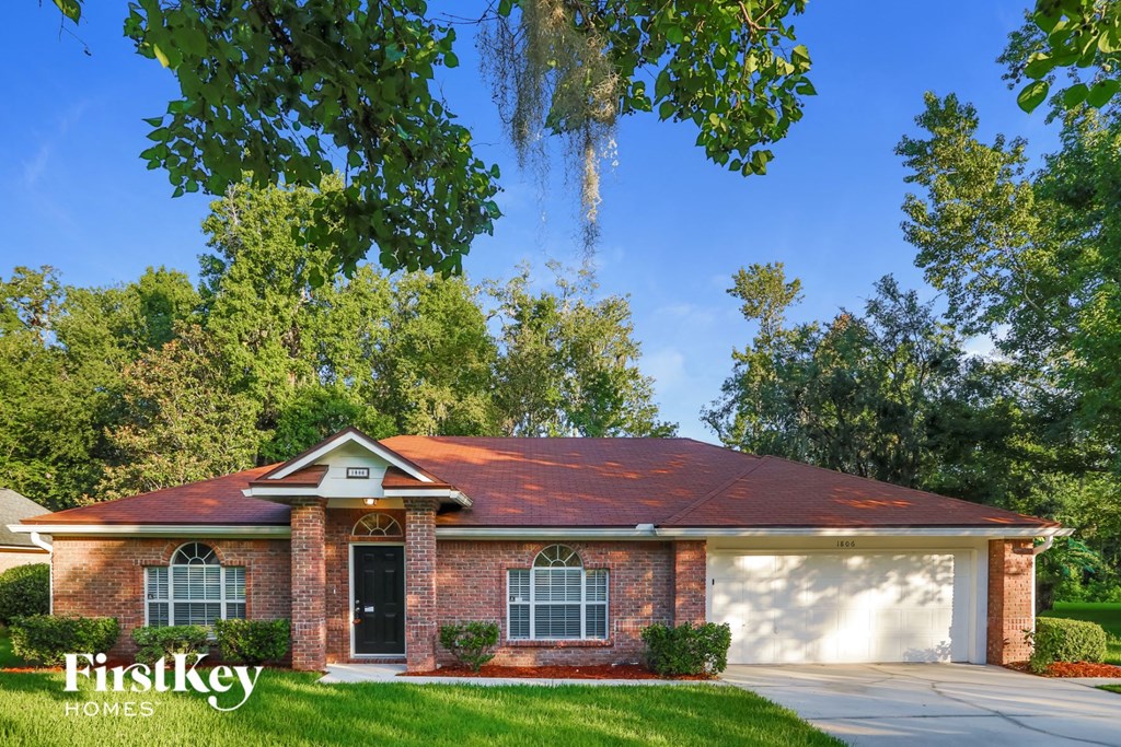 a brick house with a red roof and a garage