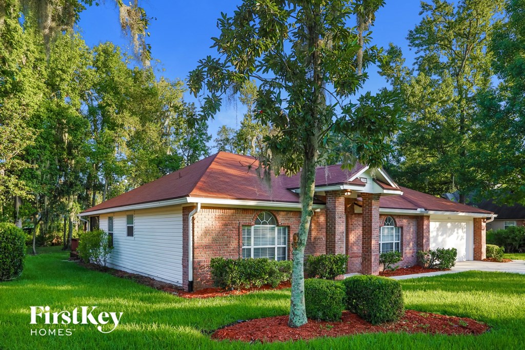 a small brick house with a tree in front of it