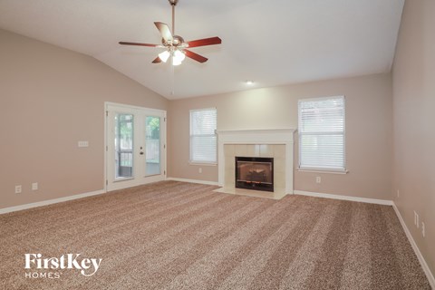 a living room with a fireplace and a ceiling fan