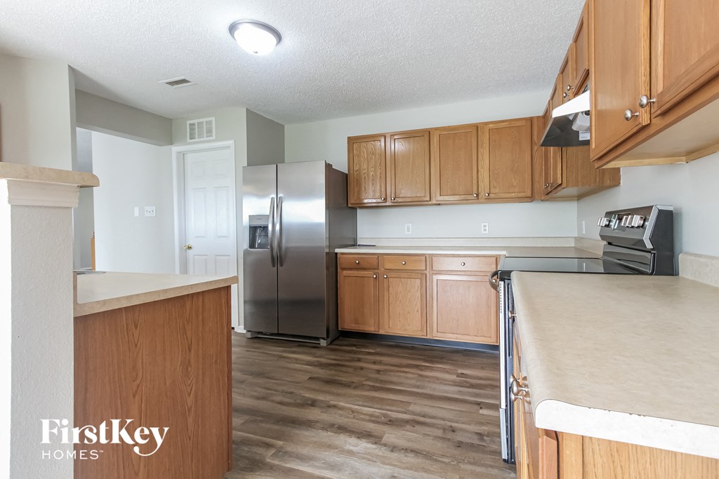 a kitchen with wooden cabinets and a stainless steel refrigerator