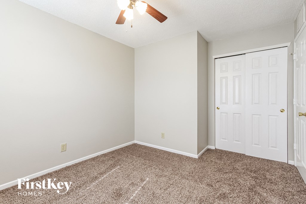 a bedroom with a carpeted floor and a white door