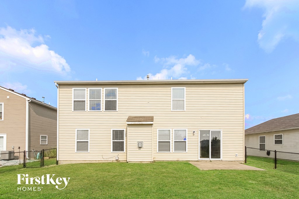a yellow house with a green lawn in front of it