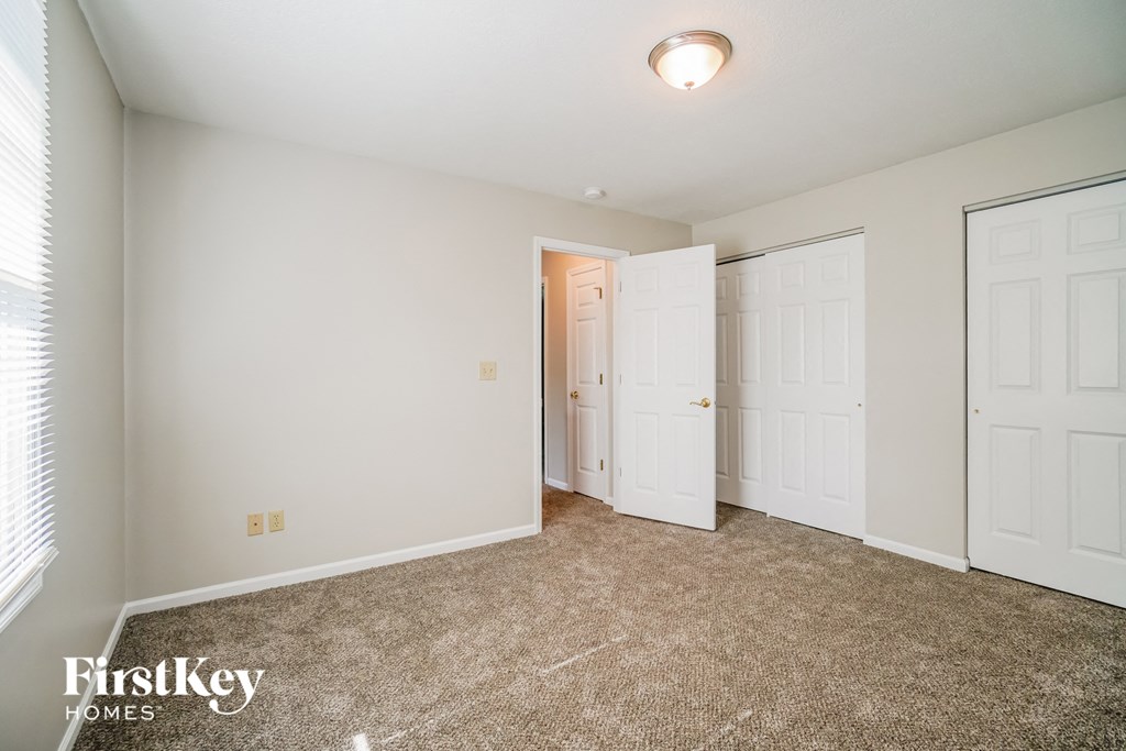 A room with a carpeted floor and a white door.