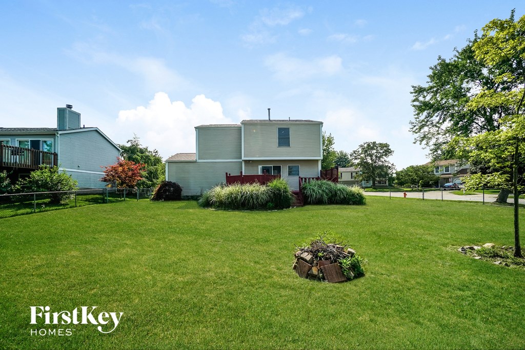 A house with a well-maintained lawn and a tree in the front yard.