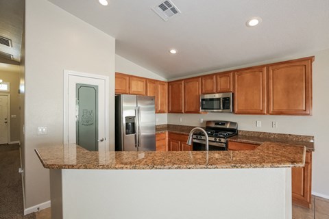 a kitchen with a granite counter top and a stainless steel refrigerator
