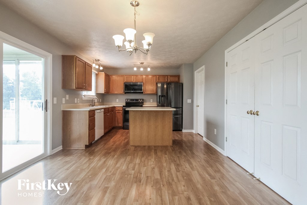 an empty kitchen with wood flooring and wooden cabinets
