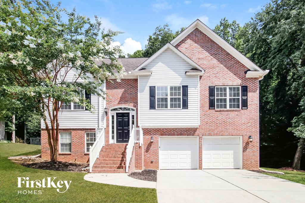 a brick house with white siding and a white garage door