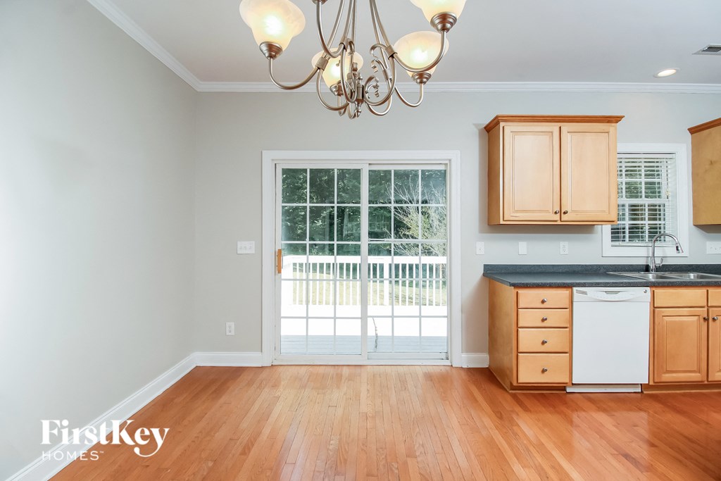 a kitchen with wood floors and a door to a balcony