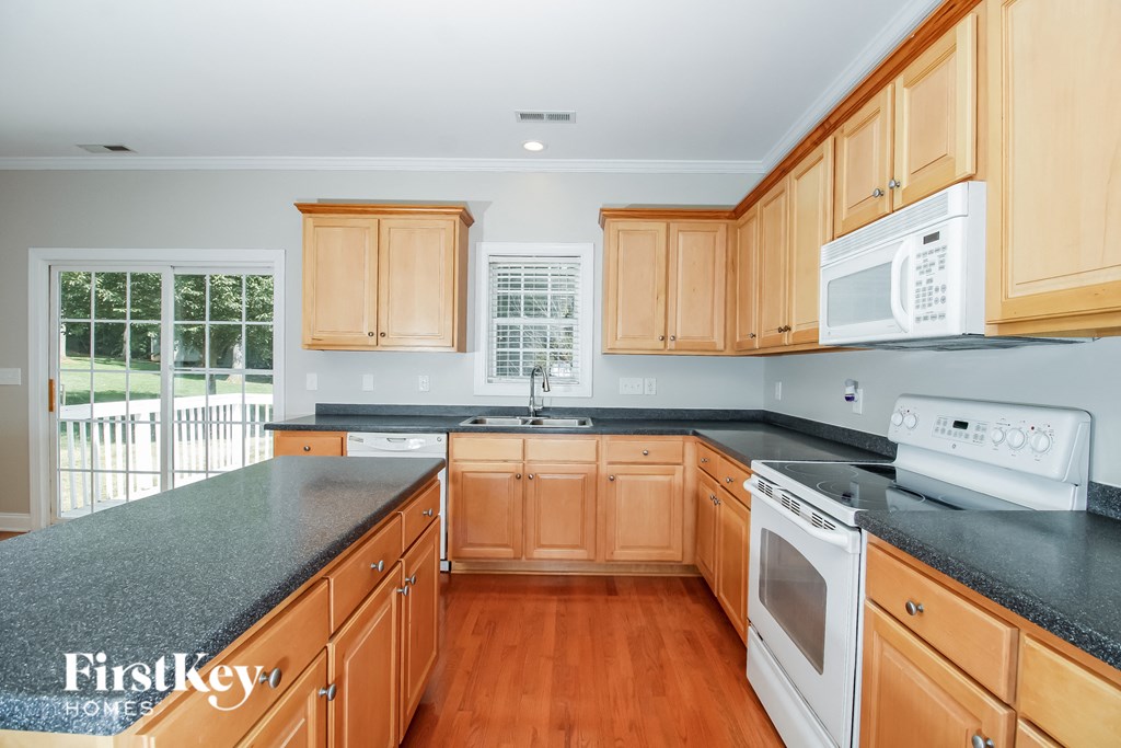 a kitchen with wooden cabinets and black counter tops