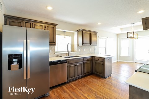 A kitchen with wooden cabinets and a stainless steel refrigerator.