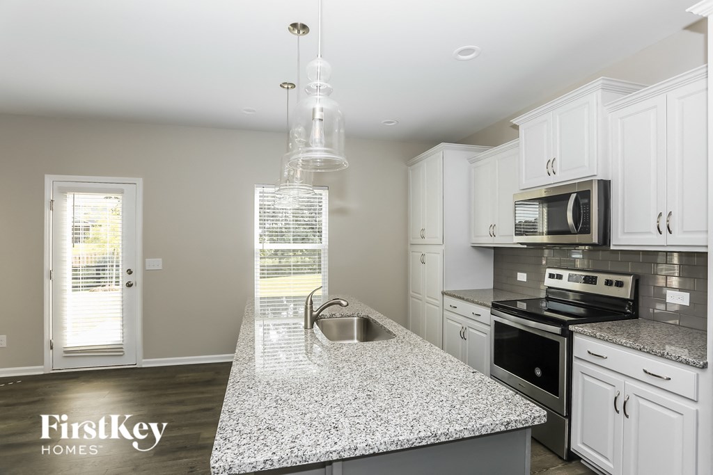 a kitchen with white cabinets and a granite counter top