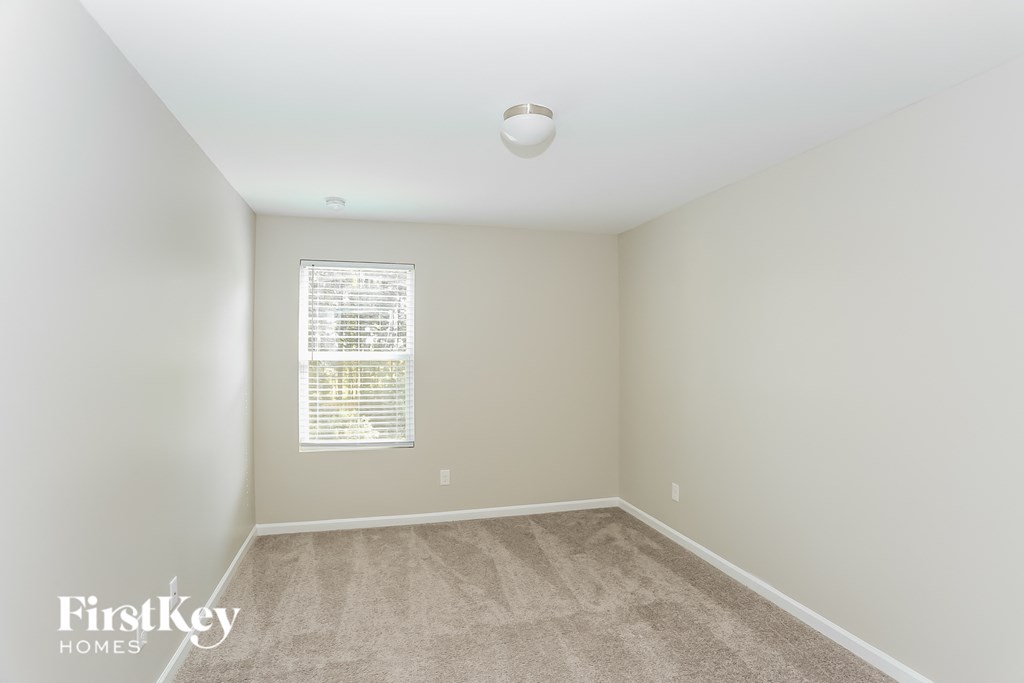 an empty room with carpet and a window