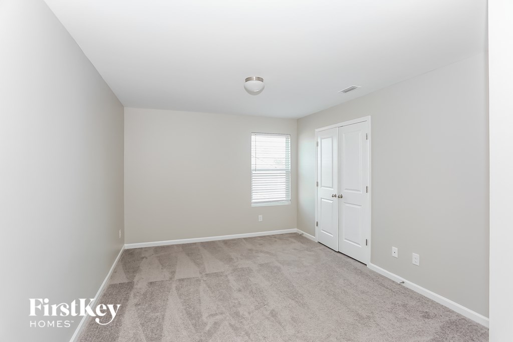 a spacious living room with white walls and a white door