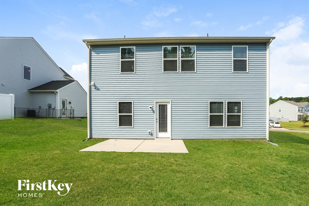 a white house with blue siding and a grassy yard