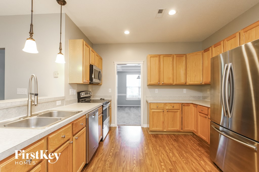 an empty kitchen with wooden cabinets and stainless steel appliances