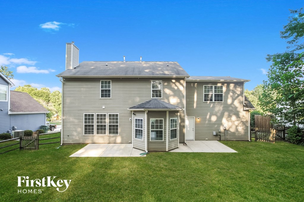 the back of a house with a yard and a backdoor