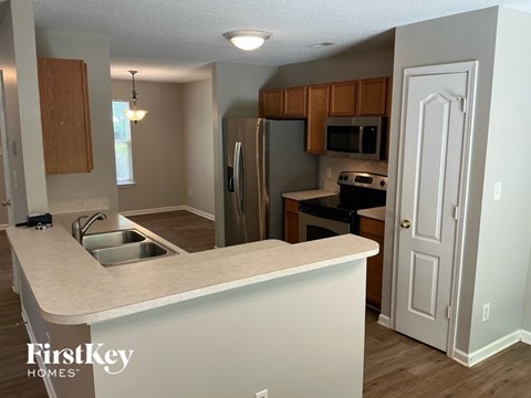 A kitchen with a white counter top and wooden cabinets.