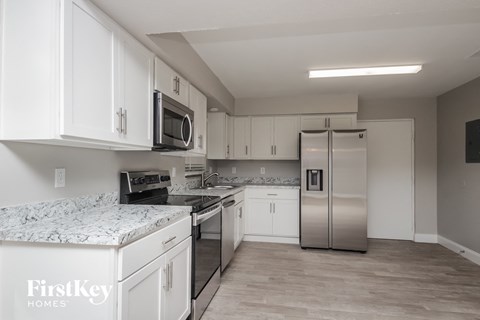 a kitchen with white cabinets and a stainless steel refrigerator