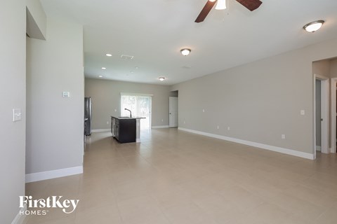 A spacious room with a ceiling fan and a large window.