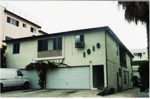 A white van is parked in front of a garage door.