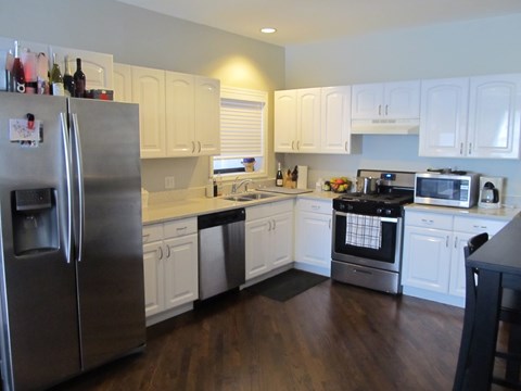 a kitchen with white cabinets and stainless steel appliances