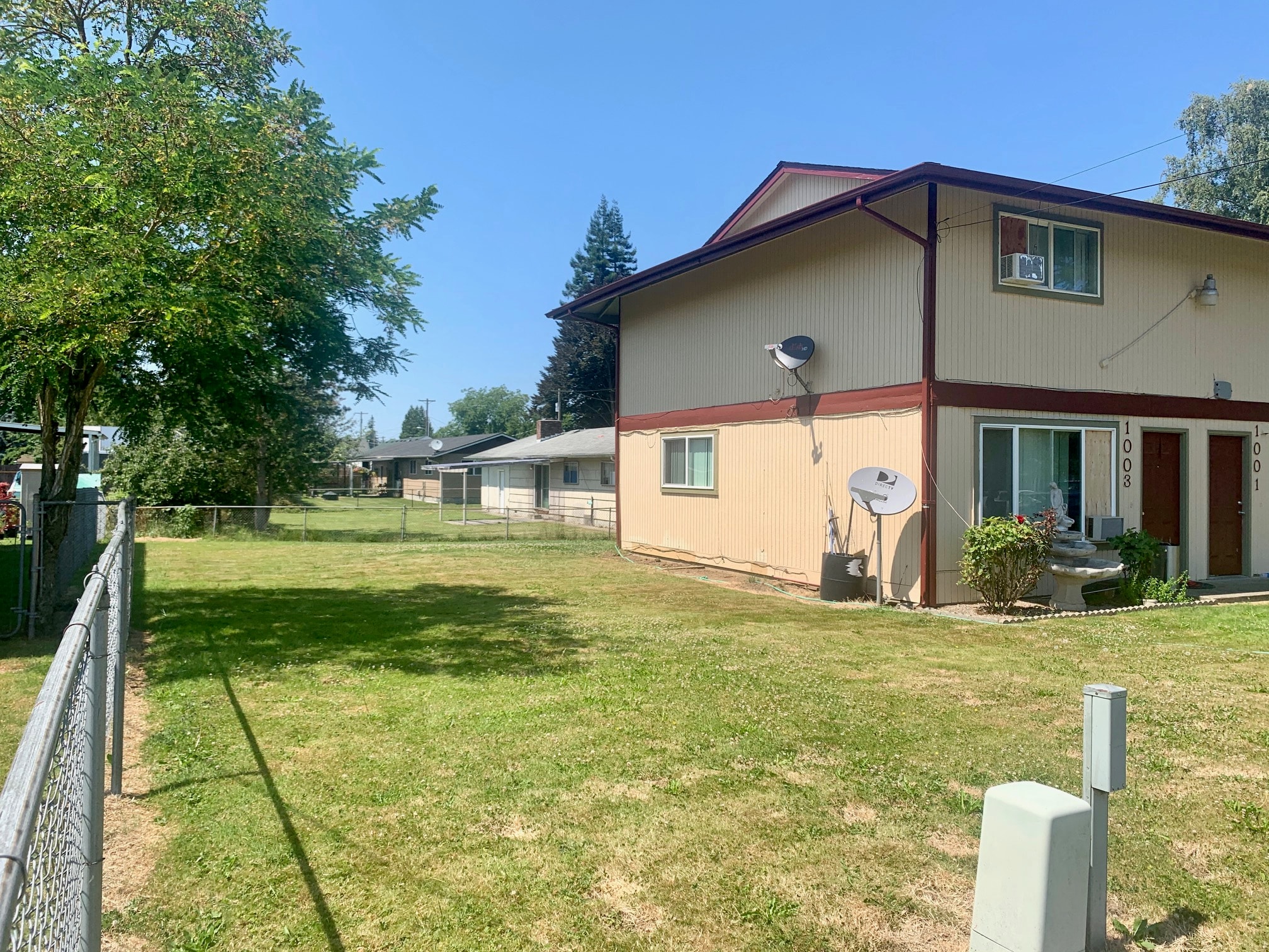a house with a yard and a fence in front of it