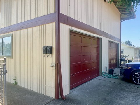 a garage with a red door and a car parked next to it