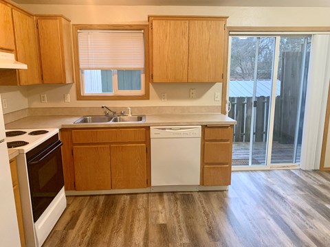 A kitchen with wooden cabinets and a white dishwasher.