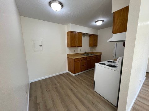 A small kitchen with a white dishwasher and wooden cabinets.