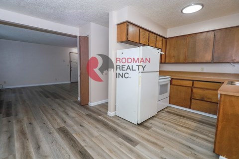 Rodman Realty Inc. sign in a kitchen with wood flooring.