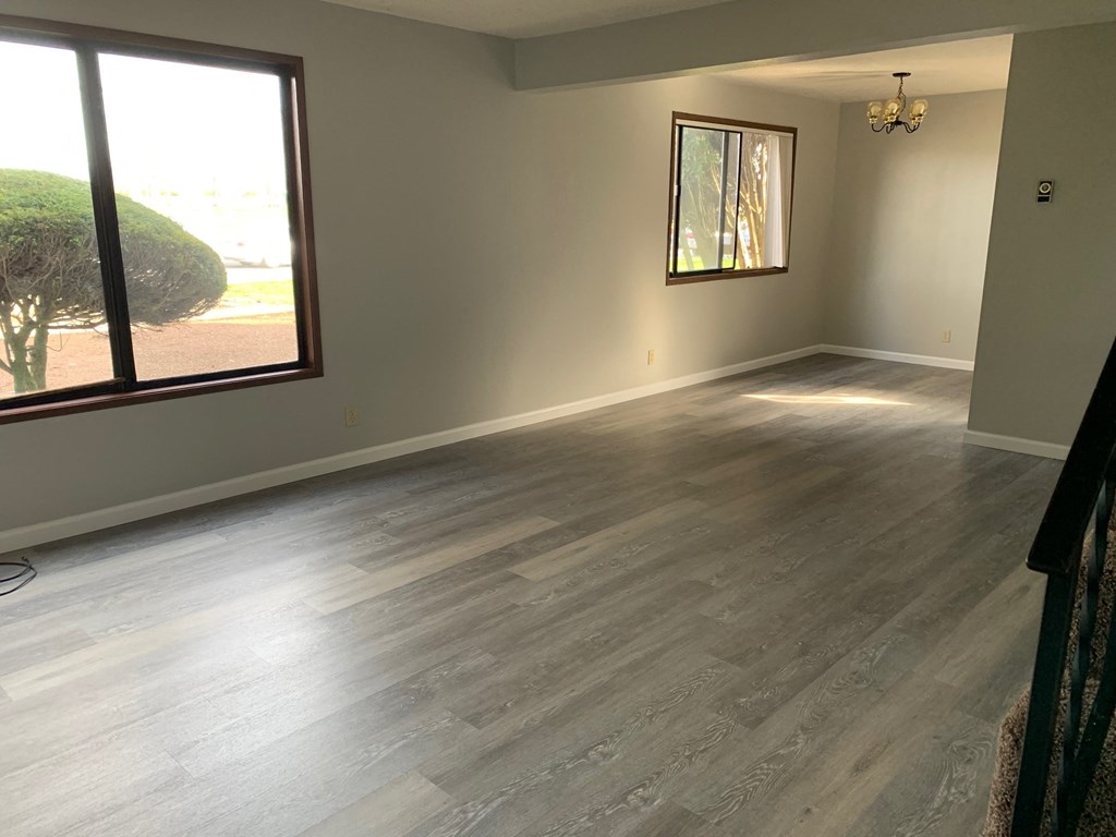 a living room with wood floors and a large window