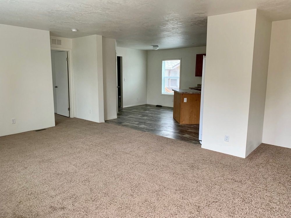an empty living room and kitchen in a house